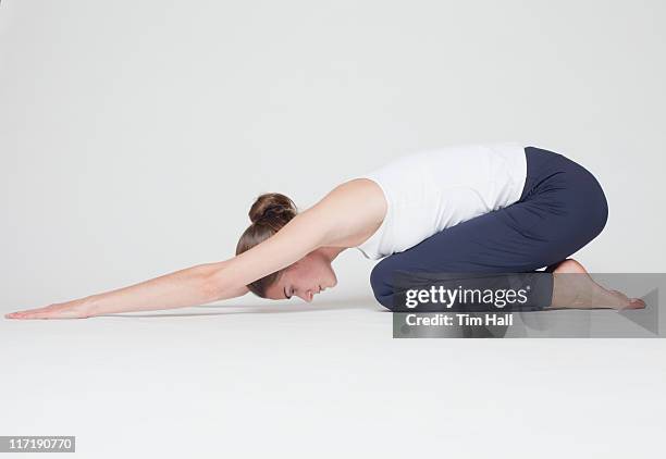 girl stretching on white background - knielen stockfoto's en -beelden