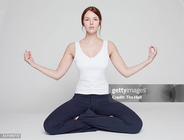 girl in lotus position on white background - atlete stockfoto's en -beelden