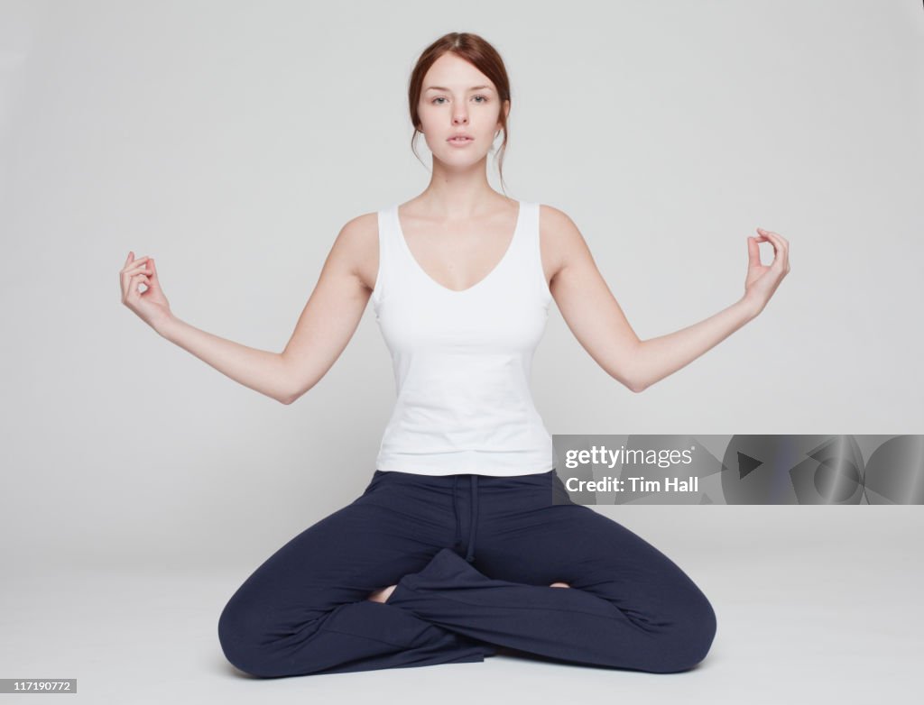 Girl in lotus position on white background