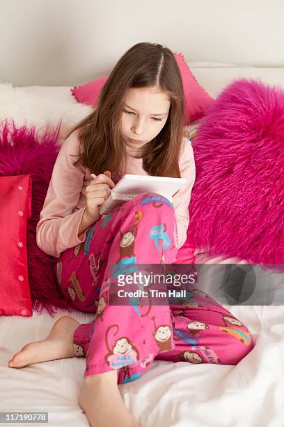 portrait of girl lying on bed - pyjama stockfoto's en -beelden