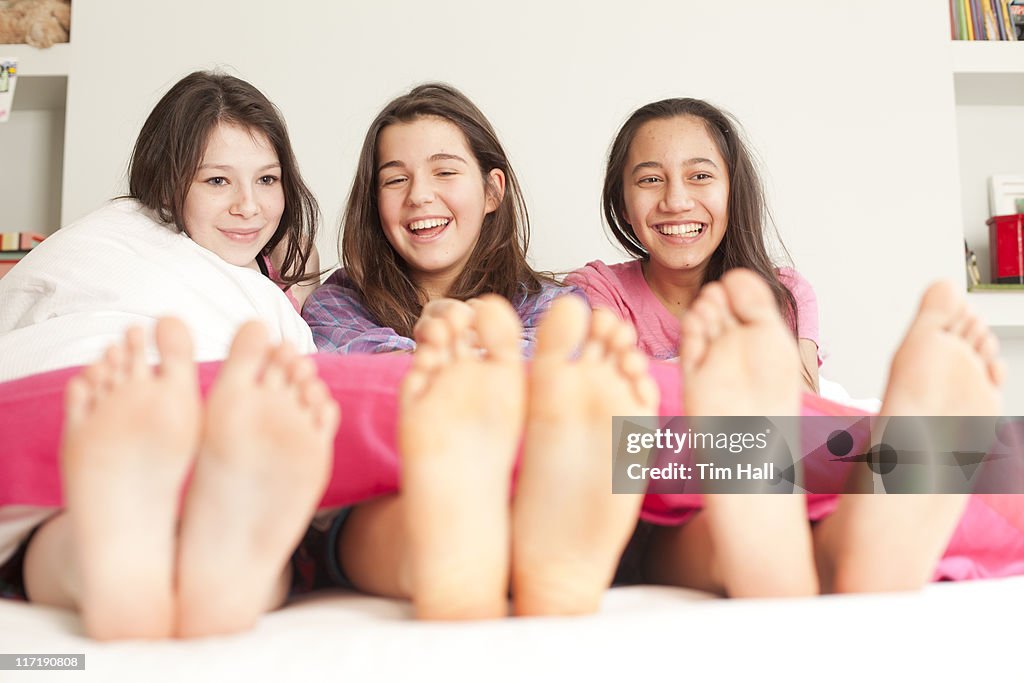 Girls lying in bed laughing