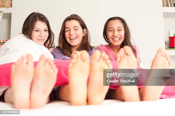 girls lying in bed laughing - teen girl barefoot at home stock pictures, royalty-free photos & images