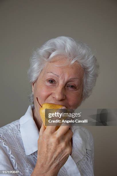 senior woman eating a pear - old angelo stock pictures, royalty-free photos & images