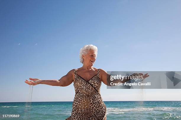 senior frau am strand - old woman in swimsuit stock-fotos und bilder