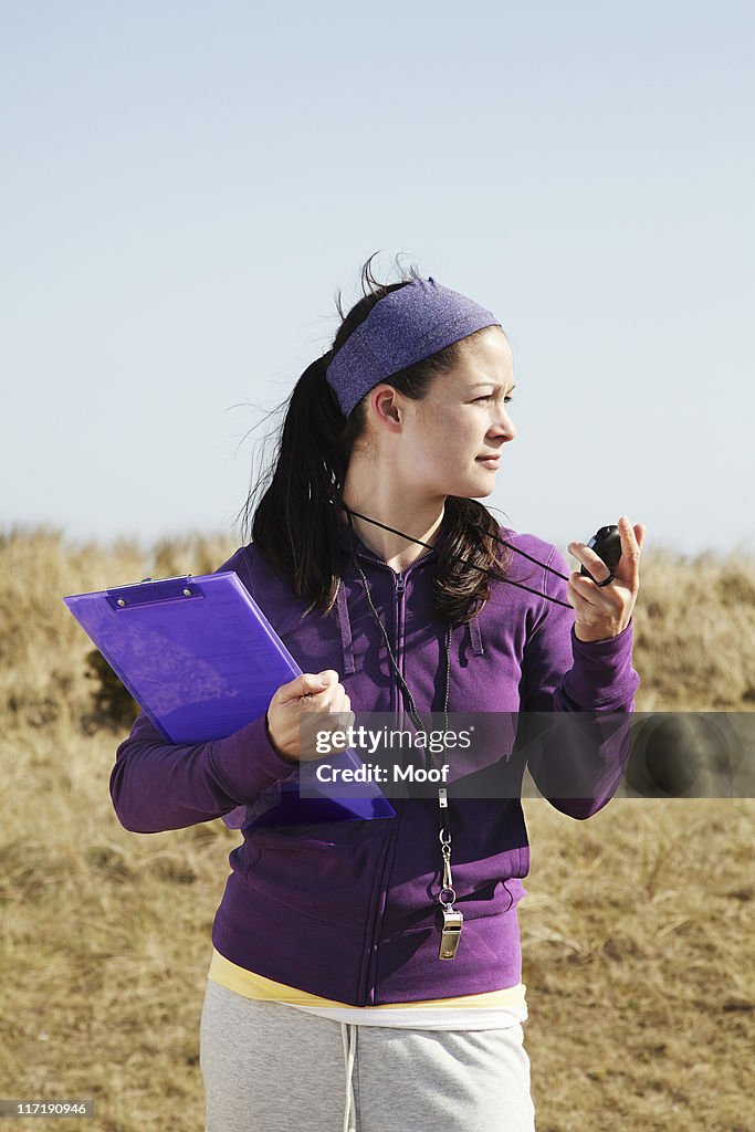 Woman holding clipboard and stopwatch