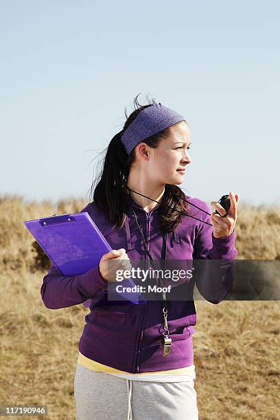 woman holding clipboard and stopwatch - coach stopwatch stock pictures, royalty-free photos & images