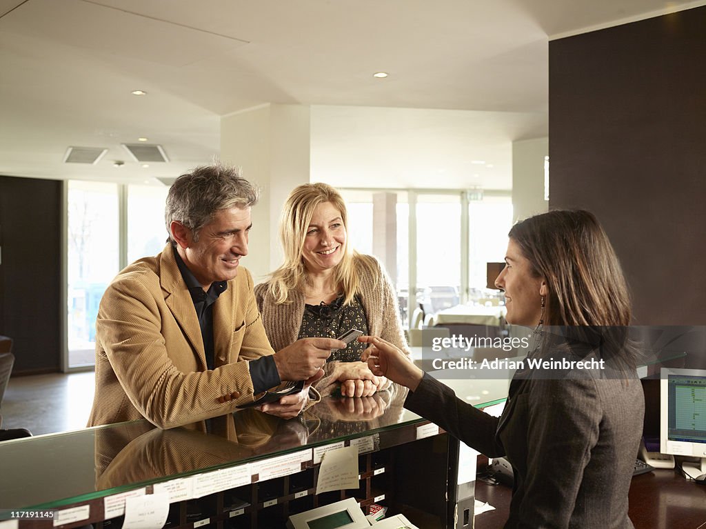 Senior Couple Paying for a Hotel Room