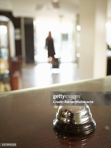 close up of hotel porters bell with woman approaching - hotel bell stockfoto's en -beelden