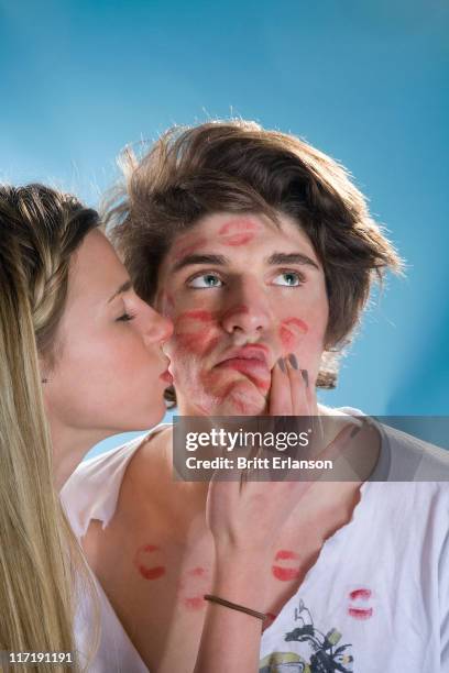 young man being kissed all over by girl - kiss face stock pictures, royalty-free photos & images