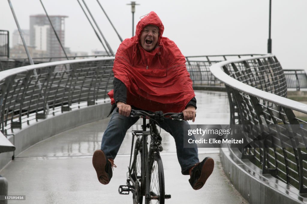 Mann in Regen Spaß am Fahrrad