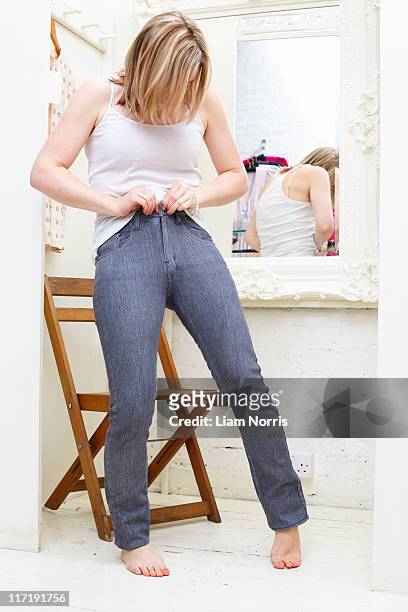 woman trying on jeans - blonde english woman shopping foto e immagini stock