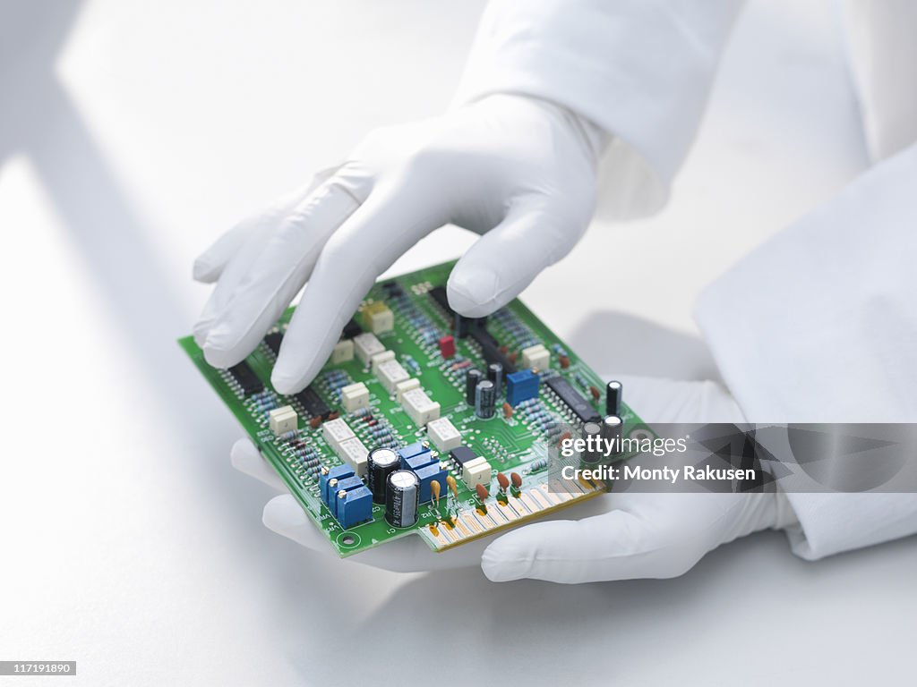 Hands holding circuit board