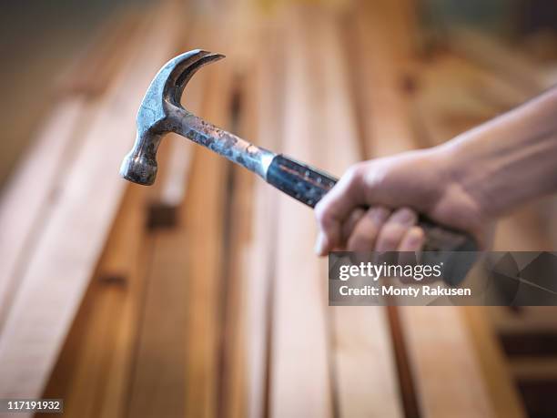 hand holding hammer next to timber - hammer stock pictures, royalty-free photos & images