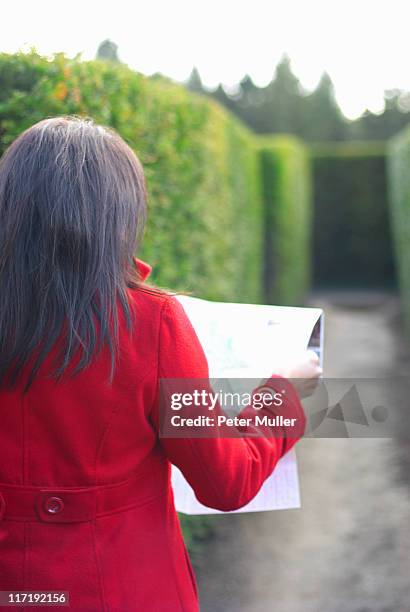 lady looking at map in a maze - escaping maze stock pictures, royalty-free photos & images