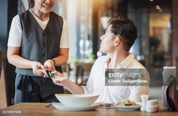 cliente pagante con carta di credito in ristorante - man eating at diner counter foto e immagini stock