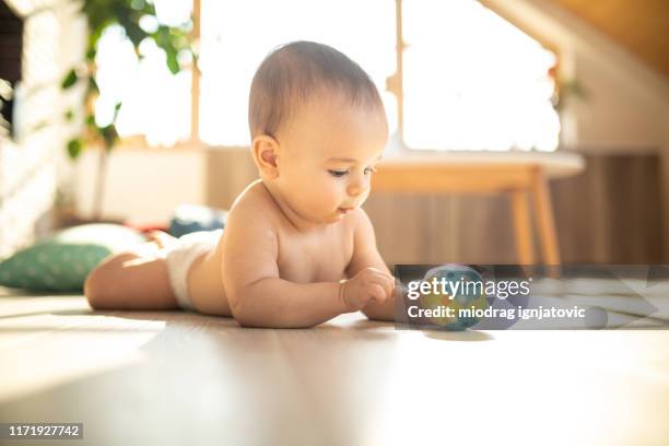 playing with his favorite toy on floor - baby reaching stock pictures, royalty-free photos & images