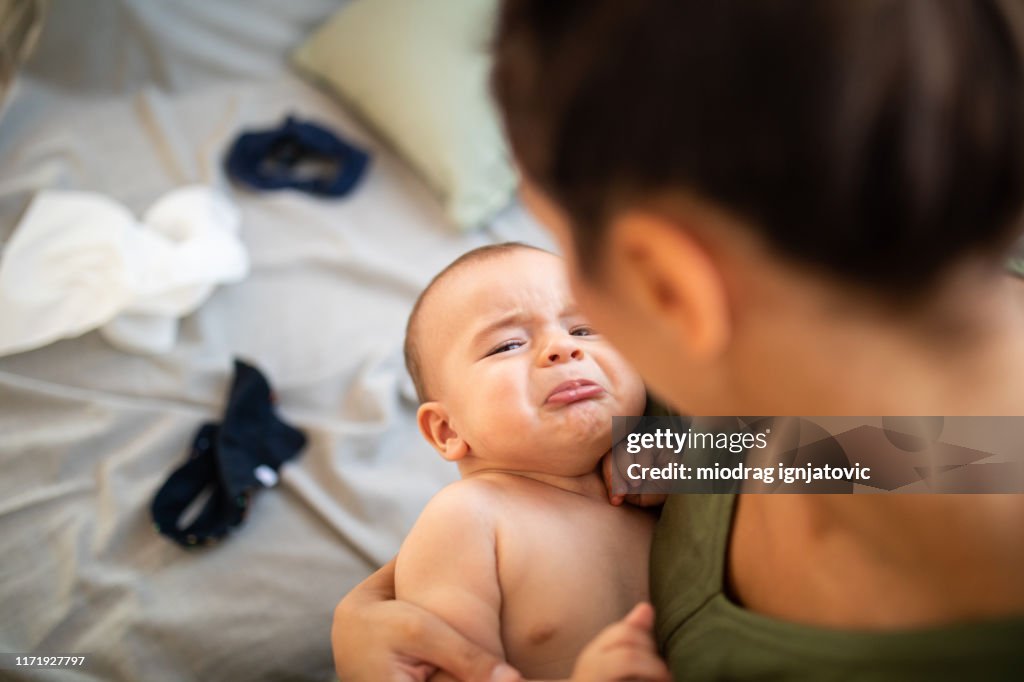 Huilen baby jongen in de armen van de moeder