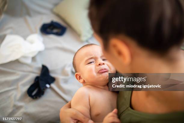 huilen baby jongen in de armen van de moeder - moms crying in bed stockfoto's en -beelden