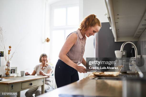 woman preparing food in kitchen - mother and daughter cooking photos et images de collection