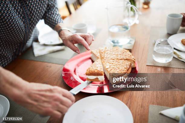 senior woman serving cake - party pies foto e immagini stock