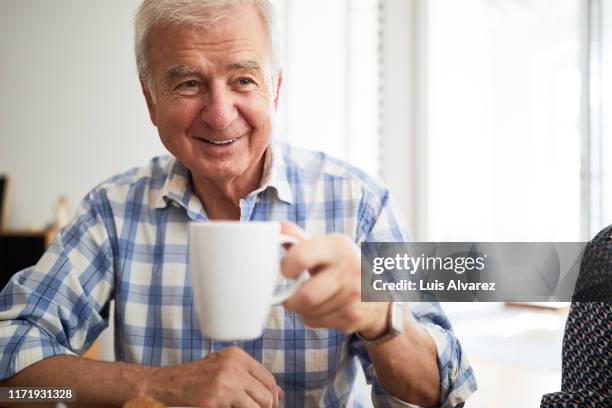 senior man having tea at home - portrait älter trinken stock-fotos und bilder