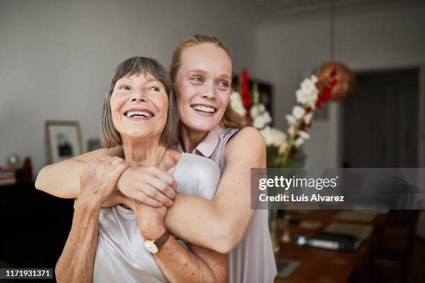 cheerful mother and daughter at home - madre e hija fotografías e imágenes de stock