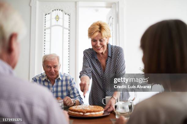senior friends enjoying meal together at home - party pies imagens e fotografias de stock