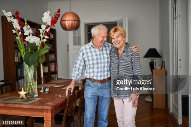 cheerful retired couple at home - ehemann stock-fotos und bilder