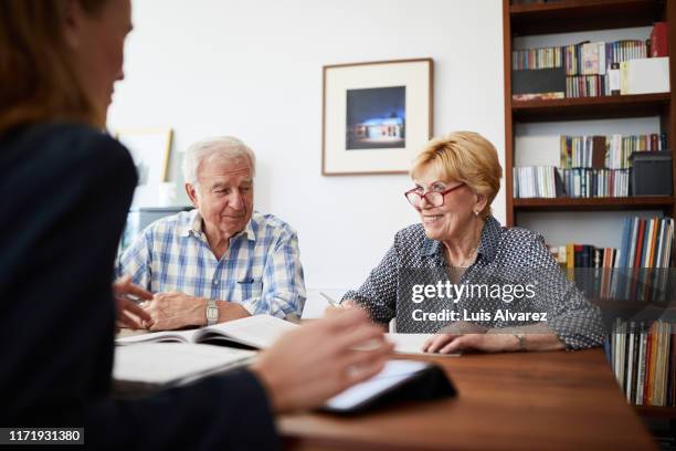 senior couple planning their investments with financial advisor - advice home stock-fotos und bilder