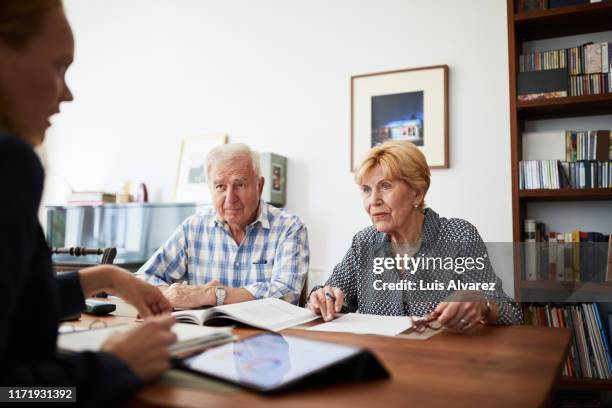 senior couple meeting with financial consultant at home - lening stockfoto's en -beelden