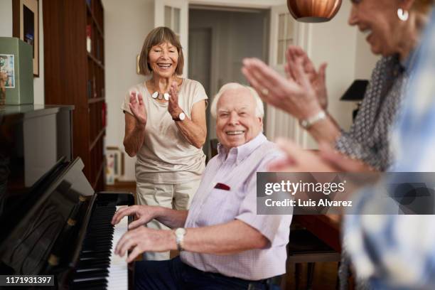 happy seniors enjoying a small get-together - pianista foto e immagini stock