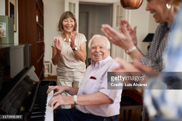 happy seniors enjoying a small get-together - piano stock pictures, royalty-free photos & images