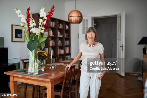 attractive retired female smiling at home - 80s living room fotografías e imágenes de stock