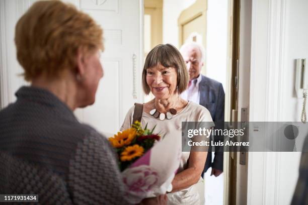 senior people visiting friends in their new home - friends at the door stock pictures, royalty-free photos & images