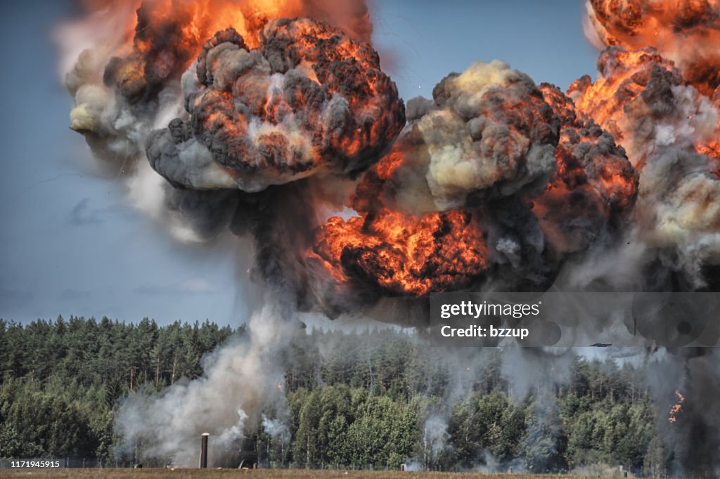 Intense explosion with fire and black smoke and sky in the background