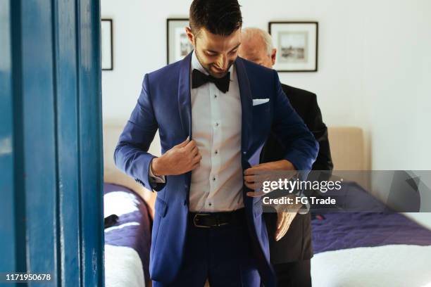 father helping groom son with his suit - changing clothes stock pictures, royalty-free photos & images