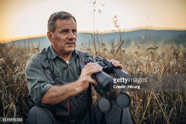 senior farmer mit fernglas - senior blaumann stock-fotos und bilder