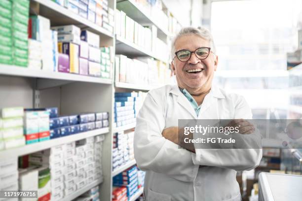 retrato de un farmacéutico senior de pie con los brazos cruzados - petite latina fotografías e imágenes de stock