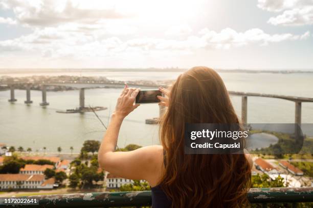 woman taking a picture of vitorias's bridge - vitória stock pictures, royalty-free photos & images