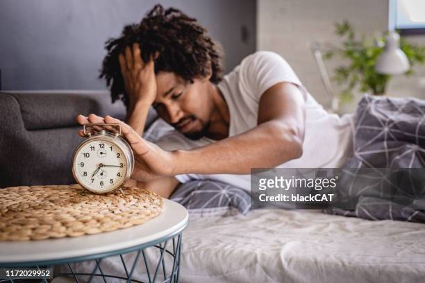 das erwachen ist stressig - black man sleeping in bed stock-fotos und bilder