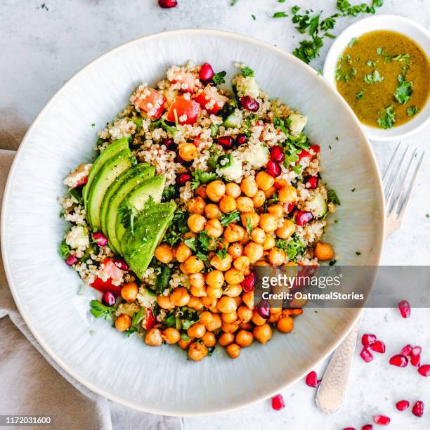 quinoa chickpea salad with tomato, cucumber, pomegranate and avocado - chick pea salad stock pictures, royalty-free photos & images