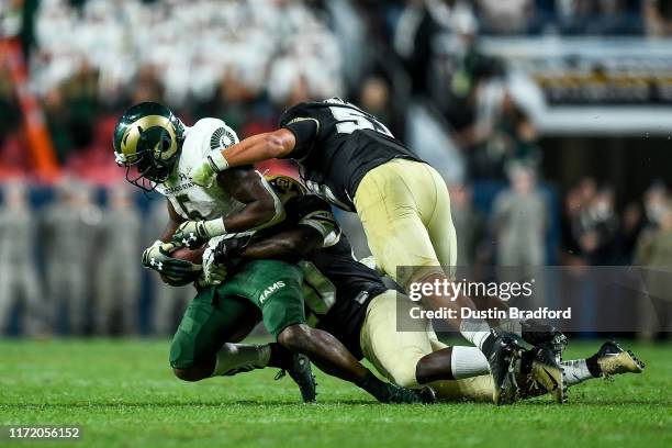 Running back Marvin Kinsey Jr. #5 of the Colorado State Rams is tackled for a loss by linebacker Davion Taylor and linebacker Nate Landman of the...