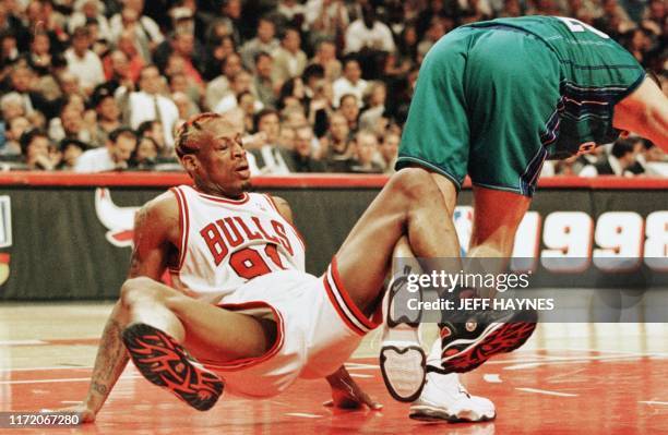 Dennis Rodman of the Chicago Bulls gets his feet tangled with Vlade Divac of the Charlotte Hornets 06 May in the second half of their NBA eastern...