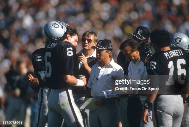 Marc Wilson of the Oakland Raiders talks with his coaches on the sidelines against the Seattle Seahawks during an NFL football game October 7, 1984...