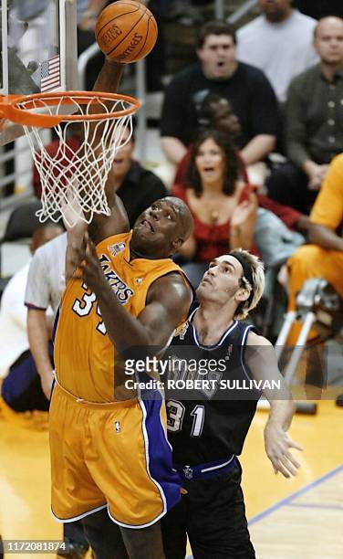 Shaquille O'Neal of the Los Angeles Lakers dunks the ball as Scot Pollard of the Sacramento Kings tries to defend during 1st quarter action of Game 6...