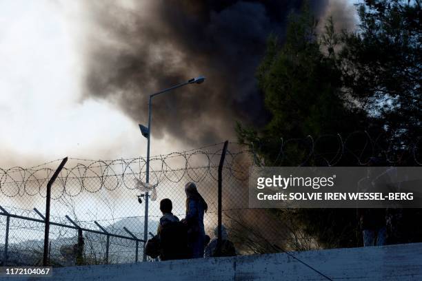 Refugees and migrants try to escape the camp of Moria after a fire broke out in the camp in Mytilene on September 29, 2019.