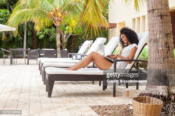 caribbean woman working from laptop - beach hotel imagens e fotografias de stock