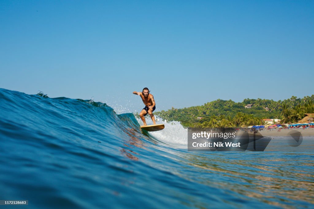Male surfer riding wave, Sayulita, Nayarit, Mexico