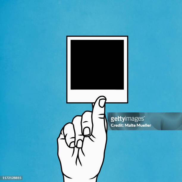 hand holding instant photograph - single object photos stock illustrations