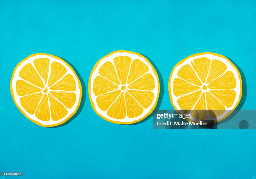 Vibrant yellow lemon slices against blue background